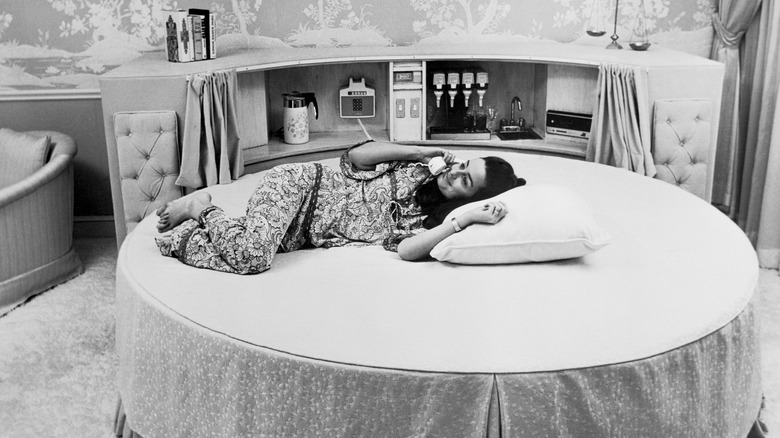 Woman lies across round bed