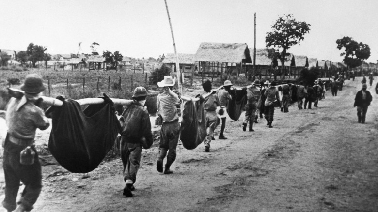 Allied soldier carrying the wounded during the Bataan Death March
