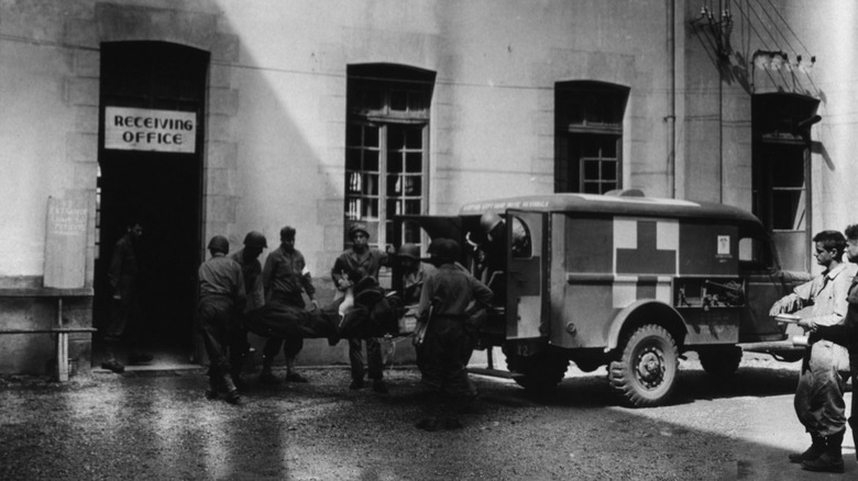 A wounded soldier being stretchered from an ambulance to the hospital