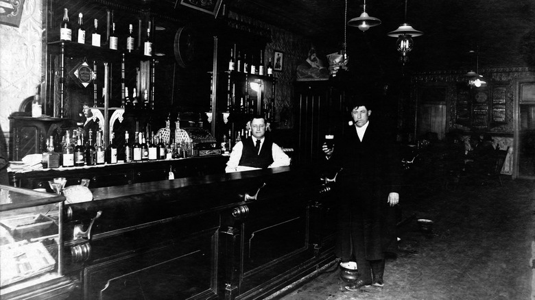 Interior of a saloon with a man holding a drink