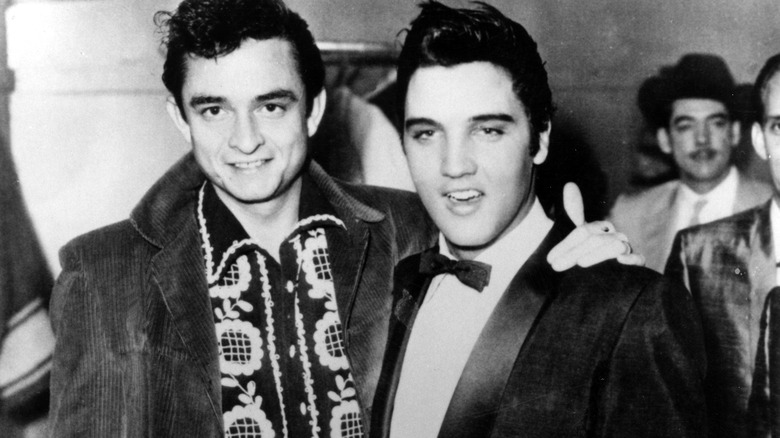 Johnny Cash with his arm around Elvis Presley
