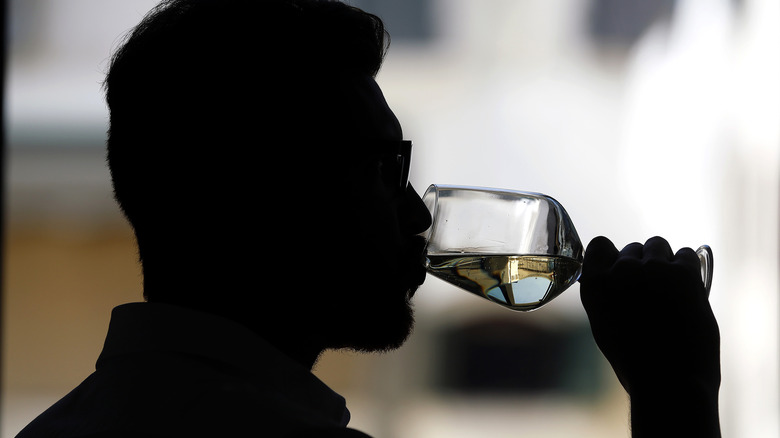 silhouette of oenologist testing wine for authenticity 