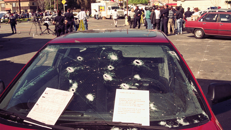 A bullet-riddled car and a crowd outside the Bank of America