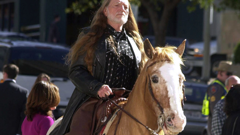 Willie Nelson riding a horse