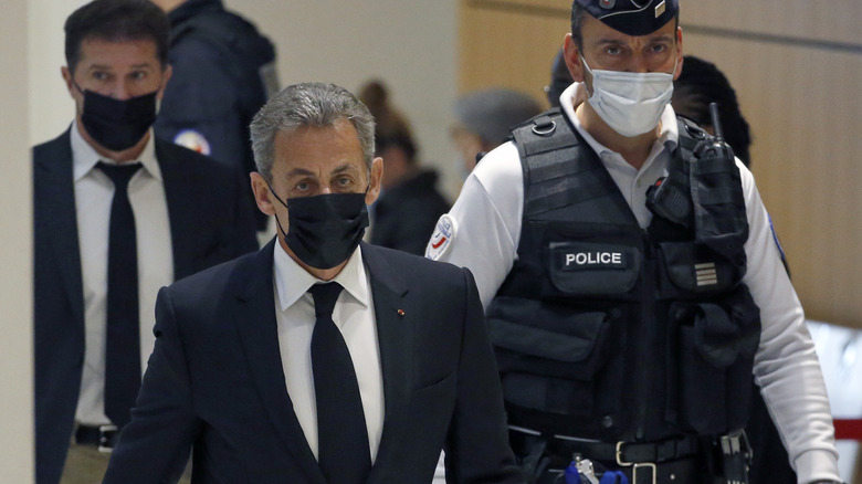 Nicolas Sarkozy and police officer walking