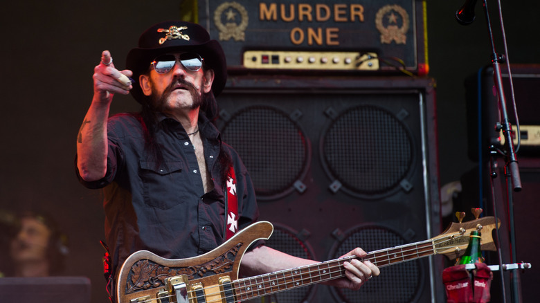 Lemmy of Motorhead pointing his finger while on stage and holding a guitar