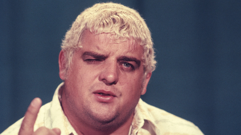 Dusty Rhodes raising his finger and speaking