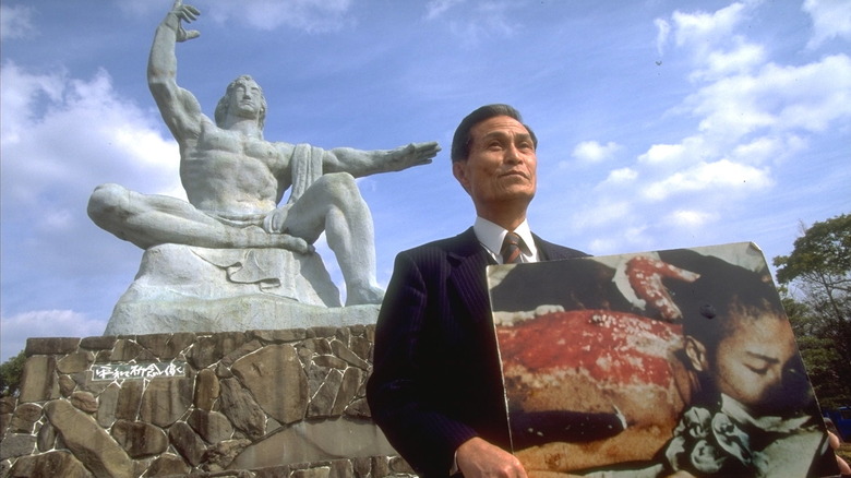 Sumiteru Taniguchi holding a photo of himself with a bloody back after Hiroshima