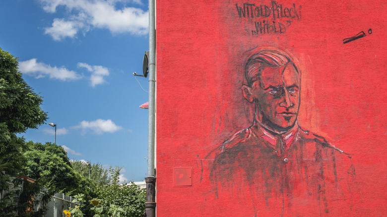 Black and red mural of Witold Pilecki on the side of a building