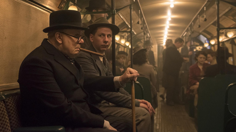 Gary Oldman as Winston Churhill sitting on recreated London underground subway car.