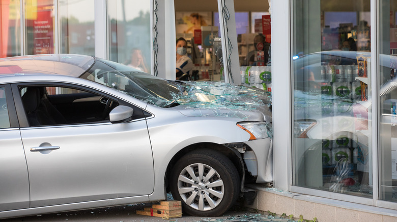 Silver sedan collides into glass storefront 