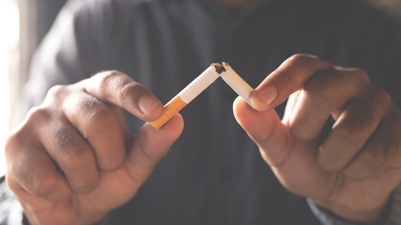 Person holding broken cigarette 
